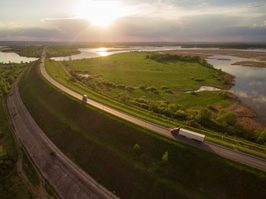 truck-on-highway-turning-corner-grrensurroundings-and-lakes-smaller