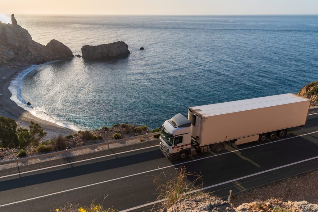 Refrigerated lorry driving next to sea