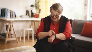 Lady smiles whilst wearing a smart care wristband